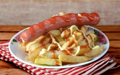 Salchipapa especial con papas artesanales y salsa de ajo, comida rápida favorita en Nariño